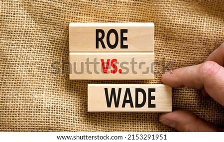 Abortion process Roe versus Wade symbol. Concept words Roe versus Wade on wooden blocks. Lawyer hand. Beautiful canvas table canvas background. Abortion process Roe versus Wade concept. Copy space.