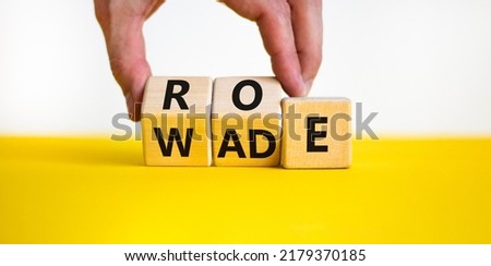 Abortion process Roe versus Wade symbol. Concept words Roe versus Wade on wooden blocks. Lawyer hand. Beautiful yellow table white background. Abortion process Roe versus Wade concept. Copy space.