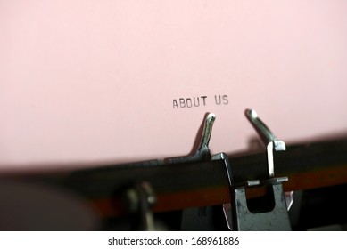 About us typing type on purple paper on typewriter