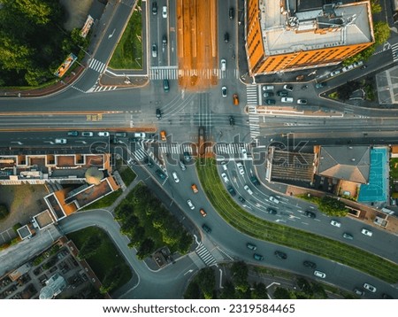From above aerial view of a crossroads, a road in the Italian metropolis of Milan on a sunny day. Modern building design of the roadway. Traffic in the city