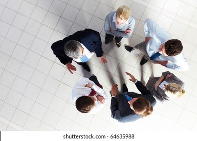 Above Angle Of Several Smart Associates Talking To Each Other At Meeting