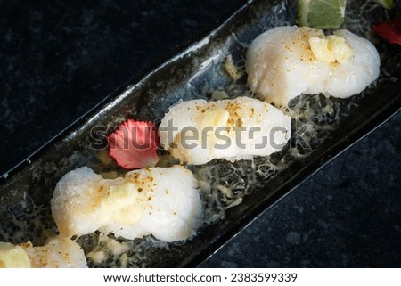 From above of appetizing and delicious nigari sushi rolls with white fish cooked rice and cheese served on black tray and placed on hard surface in daylight Stock photo © 
