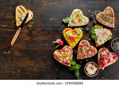 From above of assorted toasts with delicious ingredients served on dark wooden table