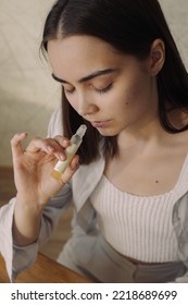 From Above Of Calm Woman Smelling Aroma Of Essential Oil While Enjoying Aromatherapy At Home 