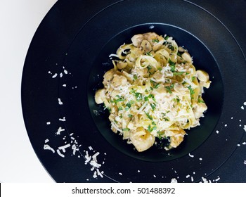 From Above, Chicken Pasta Dish With Creamy Sauce And Parmesan On A Black Plate