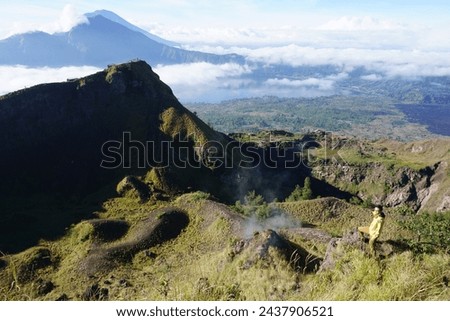 Above Cloud Nine, Mount Batur's Peak, Asian Man Trekker under Azure Sky and Cloud Sea