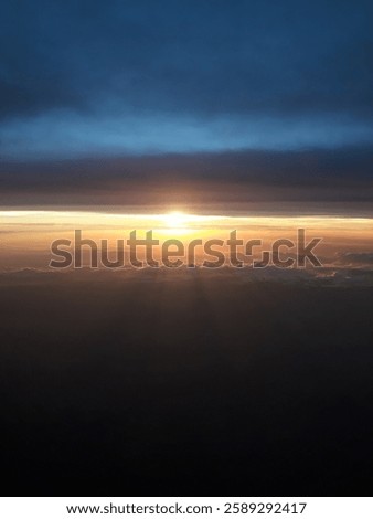 From above the clouds, the endless sky glows in shades of blue and gold. At this height, the world below fades, and the horizon stretches into a breathtaking masterpiece of light and space.