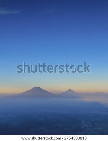 ​Location: Above the Clouds View, Central Java, Indonesia.
​Description: Stunning landscape of two volcano peaks emerging from a thick sea of clouds under a clear blue morning sky.