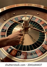 From Above Of Crop Unrecognizable Croupier Spinning Wheel Of Roulette While Working In Casino