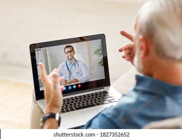 From above elderly male making video call to medical practitioner and speaking while sitting on couch at home - Shutterstock ID 1827352652