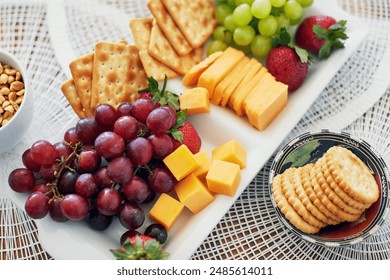 Above, food and snack platter with fruit for healthy nutrition, vegetarian diet and vitamins on table. Grapes, cheese and crackers on plate with wellness, brunch or breakfast meal and hungry eating - Powered by Shutterstock