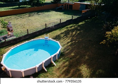 An Above Ground Pool Sets On Grass In The Backyard On A Sunny Summer Day Aerial View