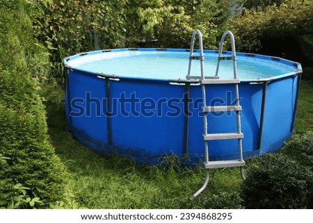 Above ground swimming pool on grass in backyard