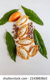 Above Half Yellow Cacao Pods And Cocoa Leaf With Brown Cocoa Beans On White Background.top View