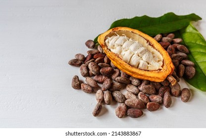 Above Half Yellow Cacao Pods And Cocoa Leaf With Brown Cocoa Beans On White Background.top View