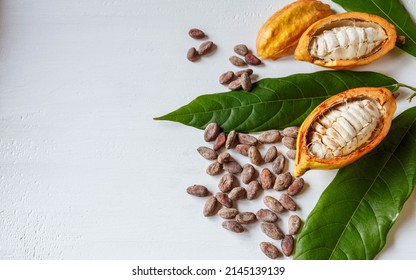 Above Half Yellow Cacao Pods And Cocoa Leaf With Brown Cocoa Beans On White Background.top View