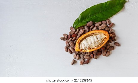 Above Half Yellow Cacao Pods And Cocoa Leaf With Brown Cocoa Beans On White Background.top View