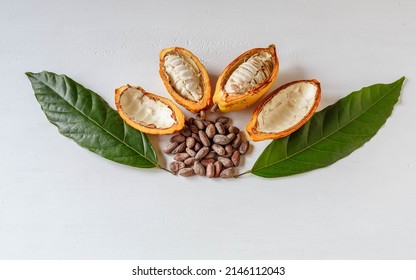 Above Half Yellow Cacao Pods And Cocoa Leaf With Brown Cocoa Beans On White Background.top View