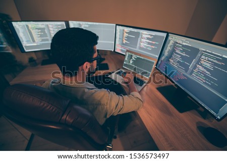 Above high angle view of his he nice senior cool qualified skilled smart clever brunet guy testing app hacking creating qa quality assurance report in dark beige room work place station