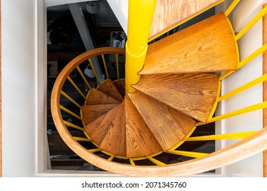 Above looking down perspective view of old vintage staircase in home interior with yellow and wood pattern architecture