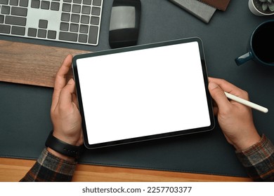 Above man hands holding digital tablet with blank screen over black leather at workspace. Empty screen for your advertise design - Powered by Shutterstock