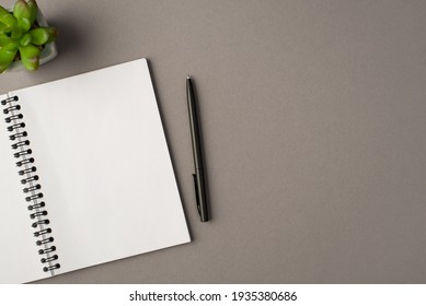 Above photo of notebook green plant and black pen isolated on the grey background with empty space - Shutterstock ID 1935380686