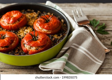 Above with prospective angle shot of pan with baked tomatoes filled with rice and chard, typical recipe of Italian cuisine.