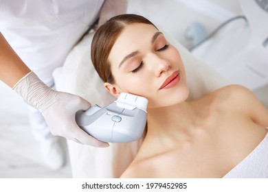 From above of relaxed young female client getting SMAS ultrasound face lifting massage with professional equipment in beauty center - Shutterstock ID 1979452985