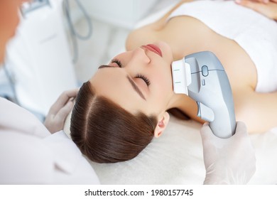 From Above Of Relaxed Young Female Client Getting SMAS Ultrasound Face Lifting Massage With Professional Equipment In Beauty Center