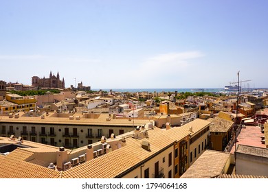Above the roofs of Palma de Mallorca with a view to the cathedral and the blue ocean.