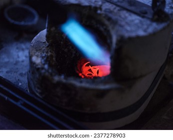 From above selective focus of burning gas torch melting metal in furnace in goldsmith workshop - Powered by Shutterstock