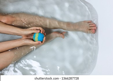 Above Shot Of Woman's Legs And Hands Holding Bath Bomb In A Tub, Bodypositive Of Self Care Concept