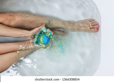 Above Shot Of Woman's Legs And Hands Holding Bath Bomb In A Tub, Bodypositive Of Self Care Concept