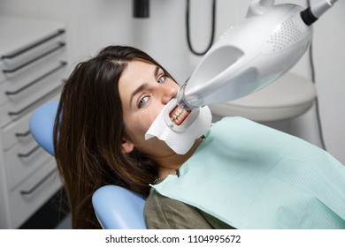 From Above Shot Of Young Woman Sitting In Chair Of Dentist Prepared For Procedure Of Teeth Whitening.