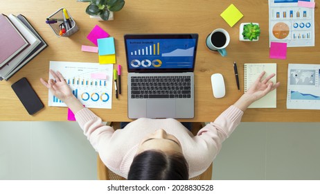 Above top view of asia girl work on desk table home office sit calm inhale deep stress relief in zen lotus yoga post. Good break rest time for teen labor people serene life in job career workforce. - Shutterstock ID 2028830528