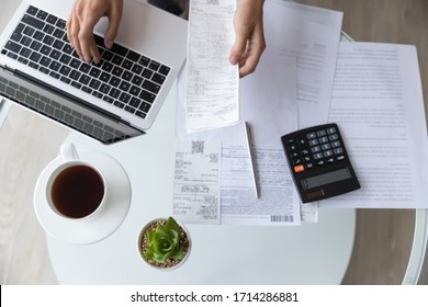 Above top view close up young woman holding utility bills or receipt, managing monthly expenses with e-banking application on computer, professional accountant or bookkeeper doing paperwork indoors. - Shutterstock ID 1714286881