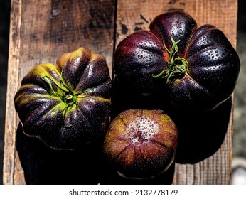 above view of American black heirloom tomatoes on rustic wooden crate
