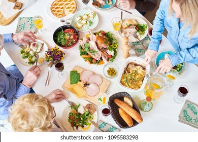 Above View Of Big Happy Family Sitting At Dinner Table Enjoying Delicious Homemade Food During Feast Celebration