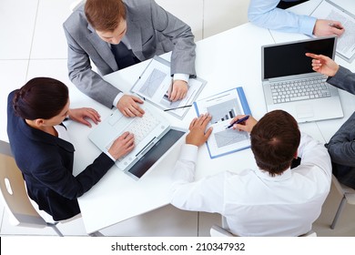 Above View Of Business Team Sitting Around Table And Working