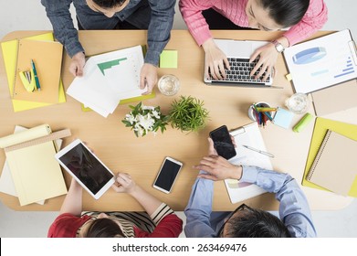 Above View Of Business Team Sitting Around Table And Working 