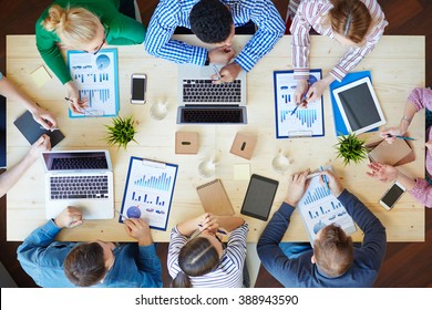 Above View Of Business Team Sitting Around Table And Working