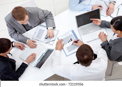 Above View Of Business Team Sitting Around Table And Working