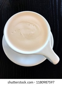 Above view of Chai tea latte on black table, portrait orientation