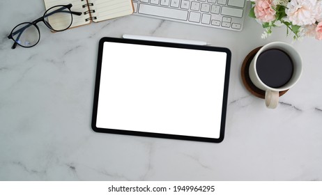 Above view of digital tablet, coffee cup, notebook and eyeglasses on marble background - Shutterstock ID 1949964295