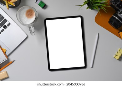 Above view digital tablet with empty display, stylus pen and camera on white desk. - Powered by Shutterstock