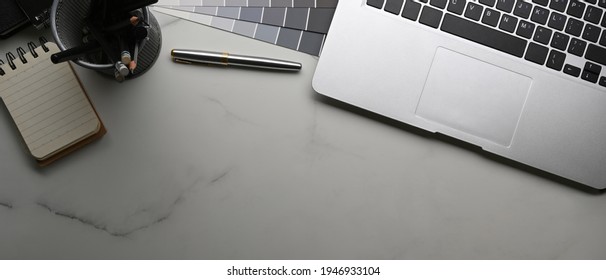 Above View Of Graphic Designer Workplace With Laptop Computer, Color Swatches, Stationery And Notebook On Marble Background.