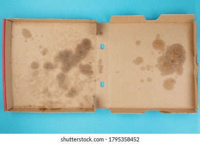 Above View Of Greasy Empty Delivery Pizza Box On Blue Background