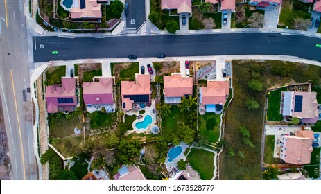 Above View Of Homes And Neighborhoods In The Temecula And Murrieta California In Riverside County With Pools, Solar Panels And Tops Of Roofs With Green Trees And Sun Setting Light. 