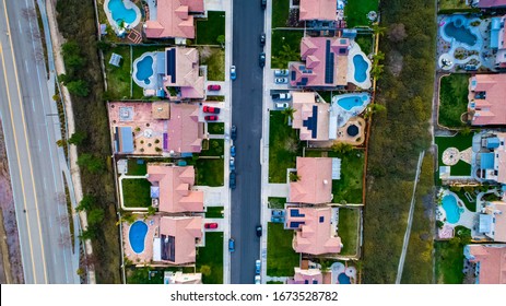 Above View Of Homes And Neighborhoods In The Temecula And Murrieta California In Riverside County With Pools, Solar Panels And Tops Of Roofs With Green Trees And Sun Setting Light. 