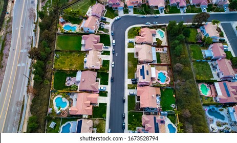 Above View Of Homes And Neighborhoods In The Temecula And Murrieta California In Riverside County With Pools, Solar Panels And Tops Of Roofs With Green Trees And Sun Setting Light. 